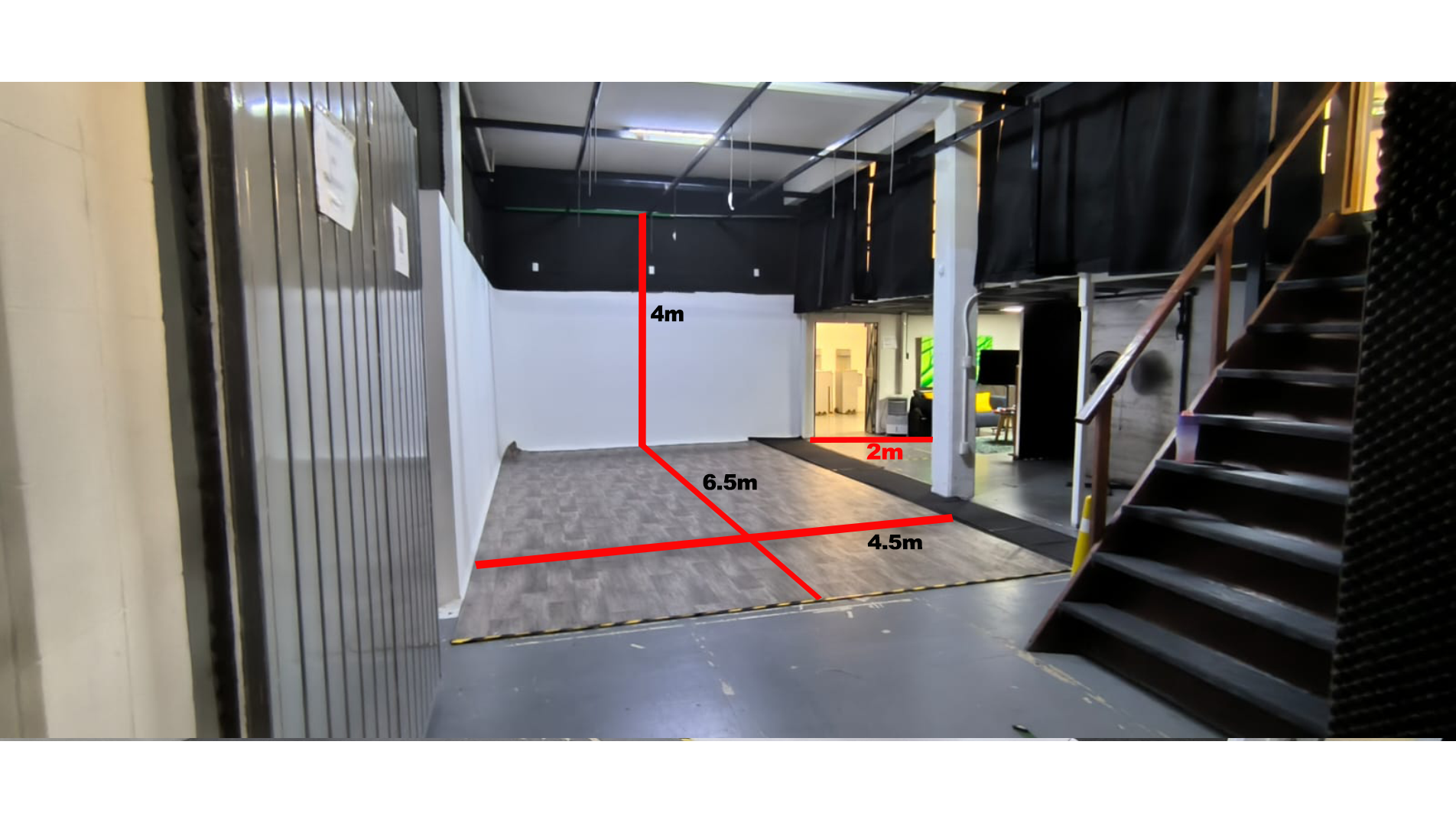 Una habitación vacía con escaleras y una línea roja en el suelo.