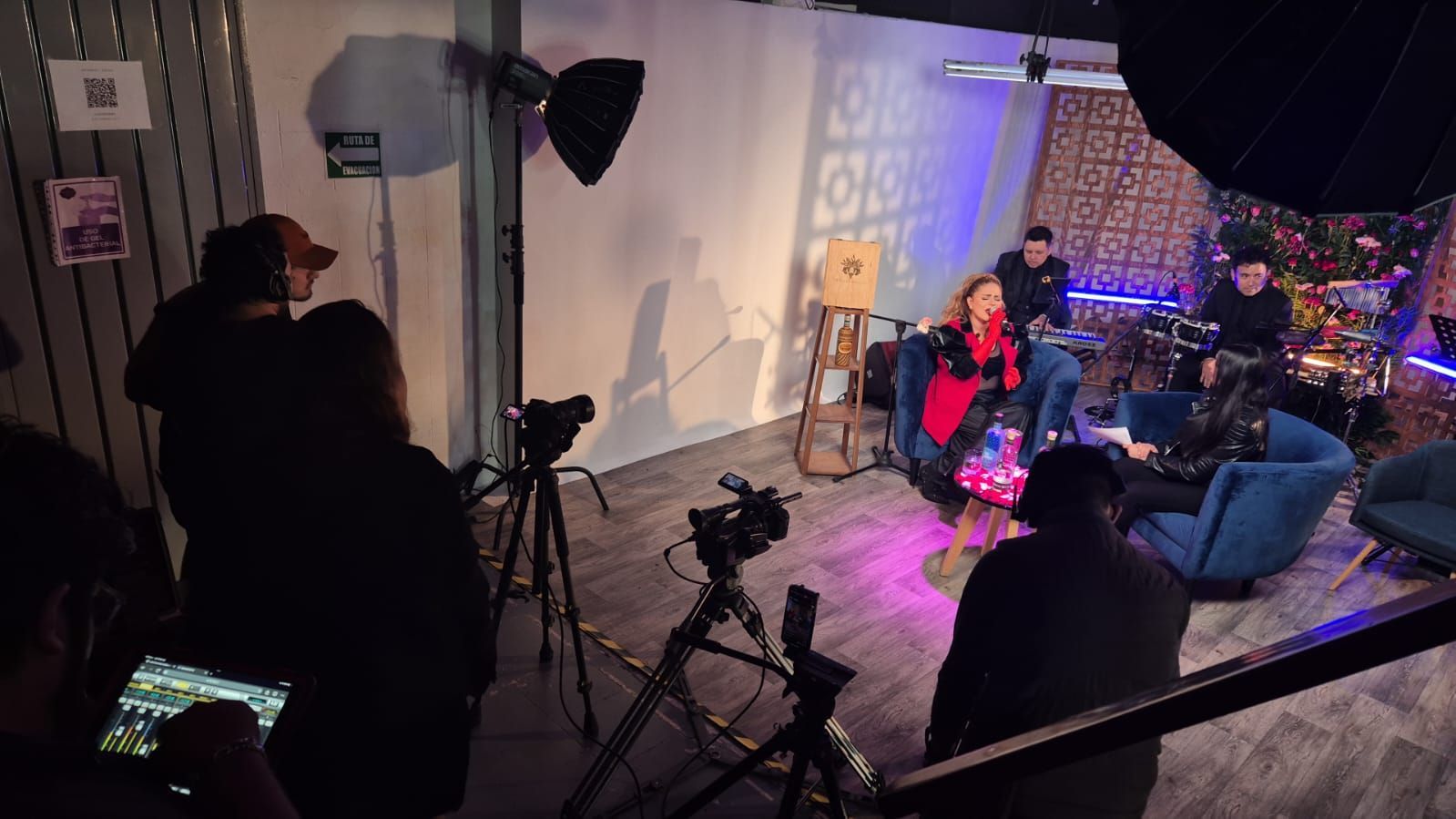 Un grupo de personas está sentado frente a una cámara en una habitación.