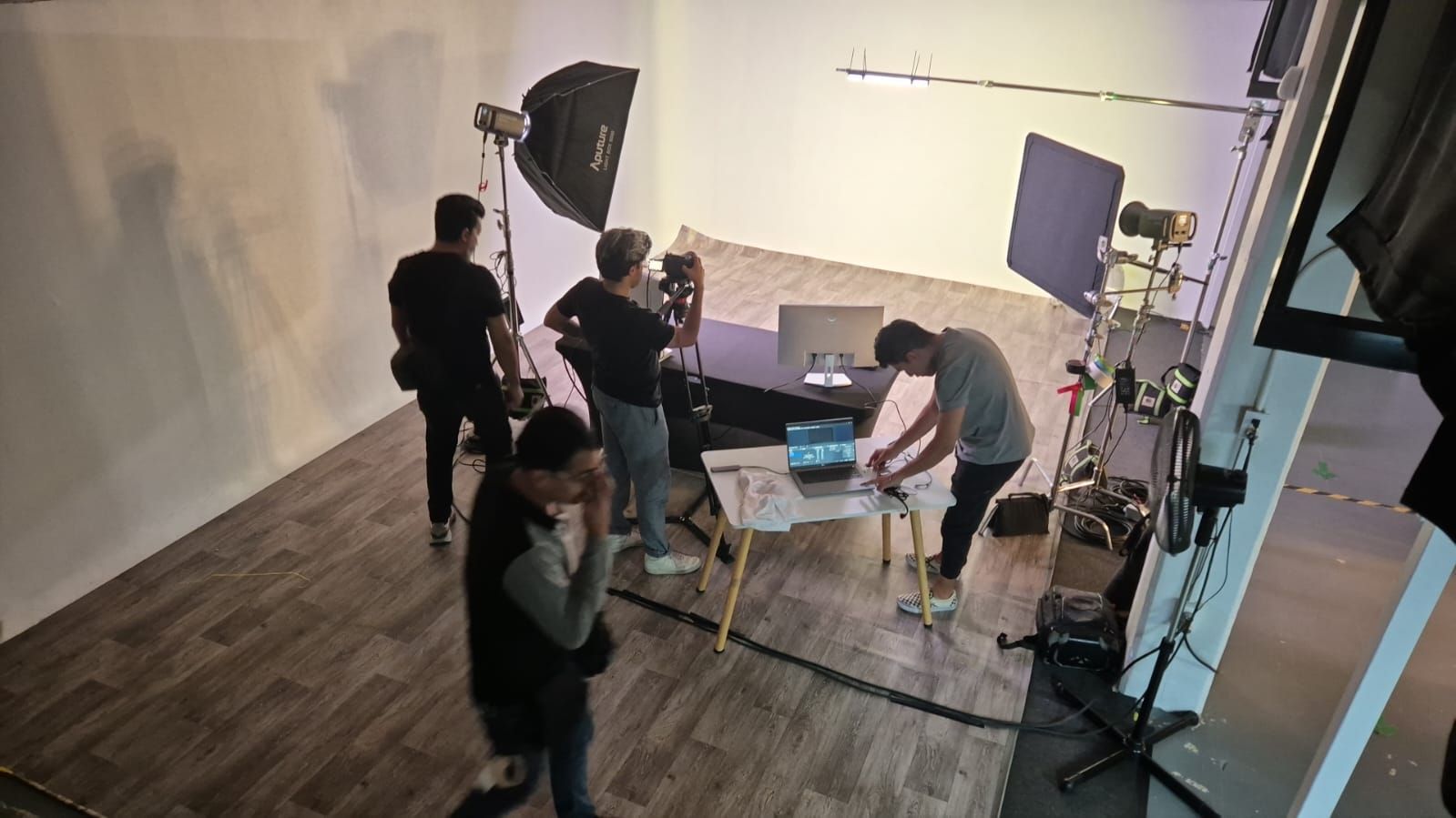 Un grupo de personas están de pie alrededor de una mesa en un estudio.