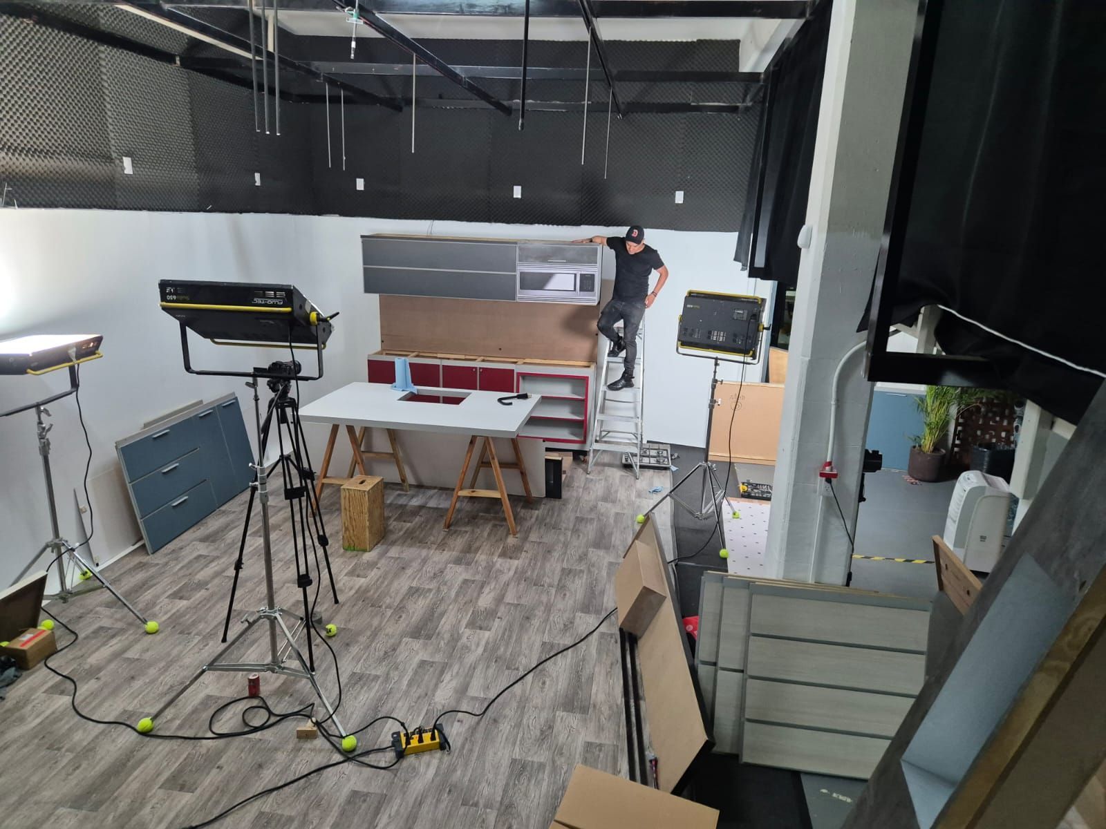 Un hombre está de pie en una escalera en una habitación con mucho equipo.