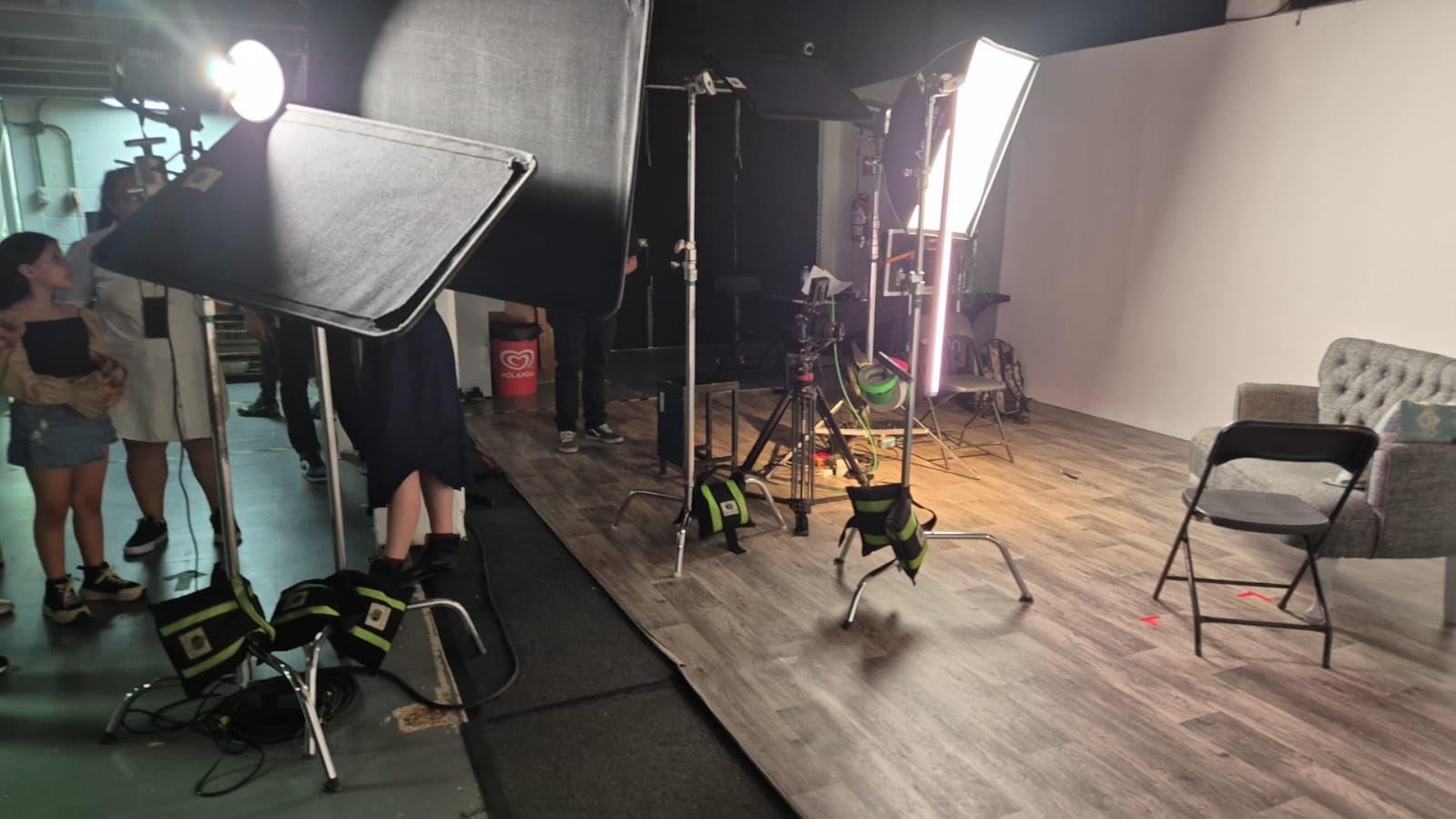 Un grupo de personas está de pie en una habitación con un sofá y sillas.