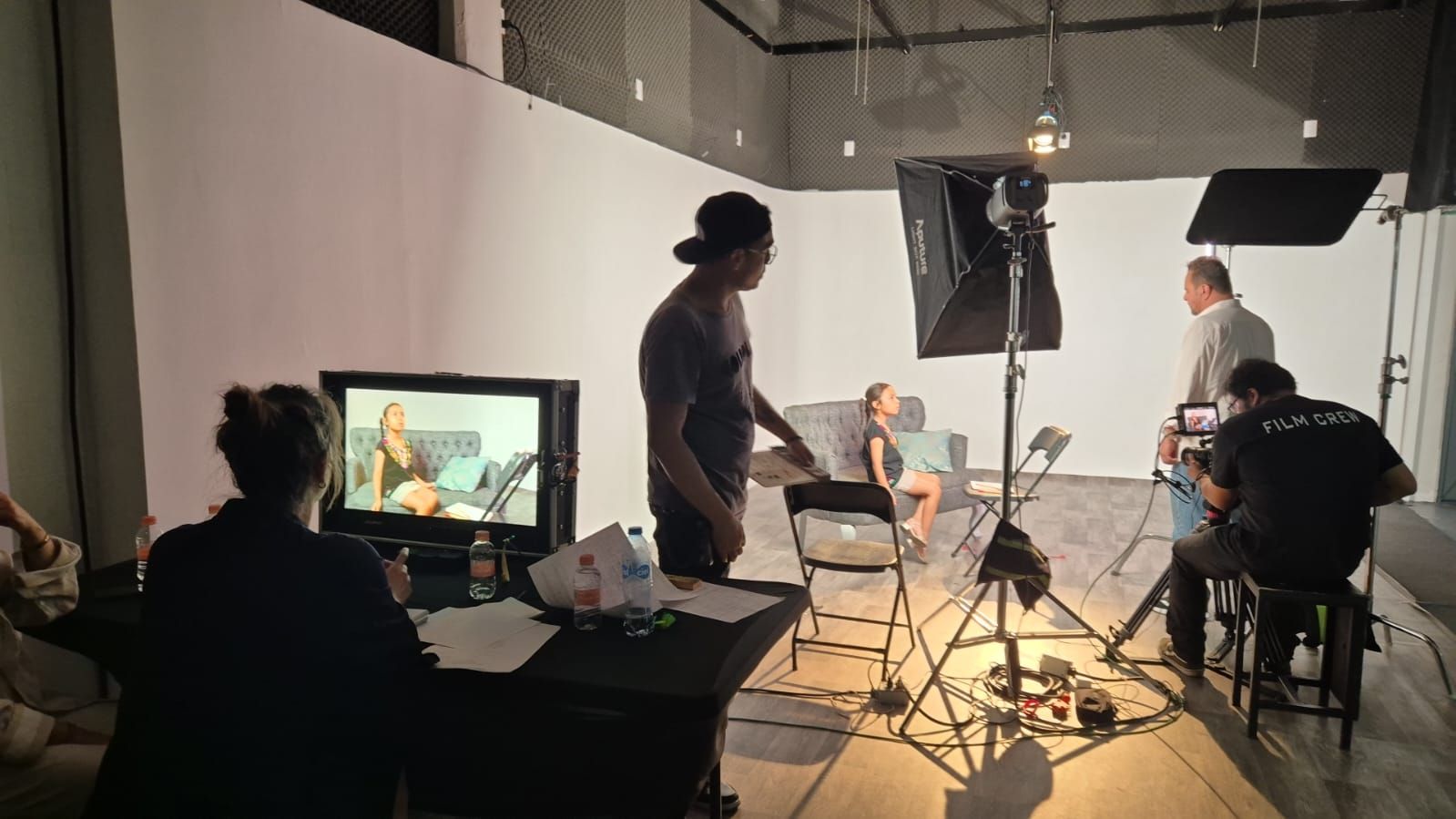 Un grupo de personas está sentada alrededor de una mesa en un estudio.