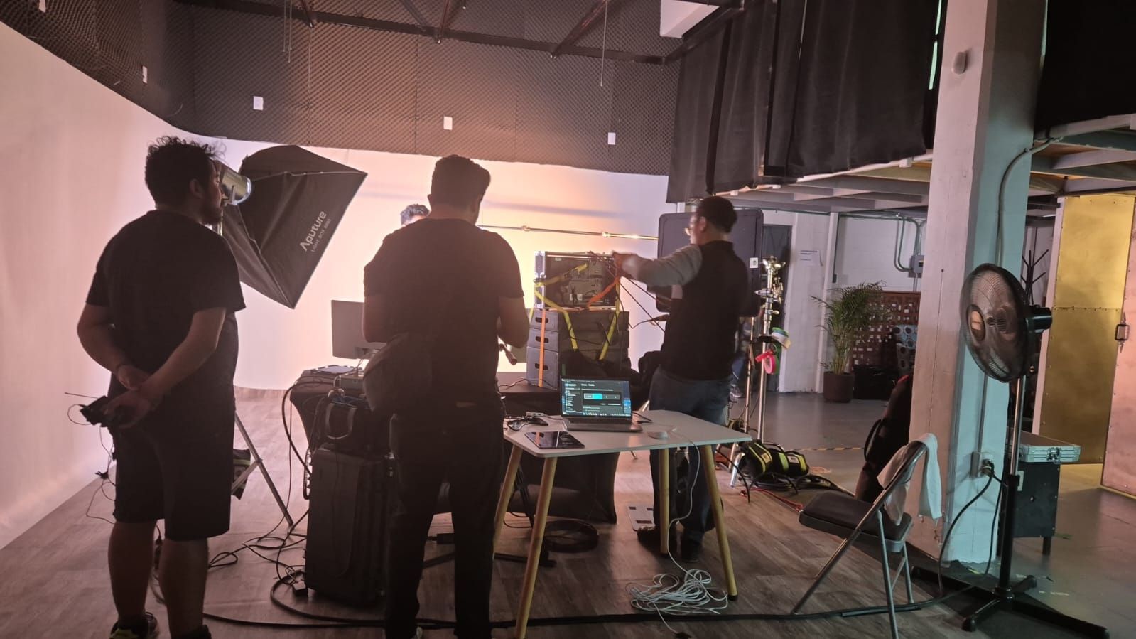 Un grupo de hombres están de pie alrededor de una mesa en una habitación.