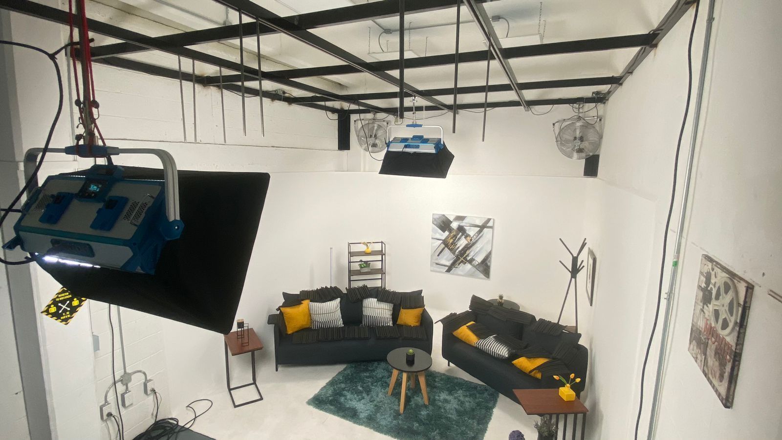 Una sala de estar con sofá, mesa y sillas en un estudio.