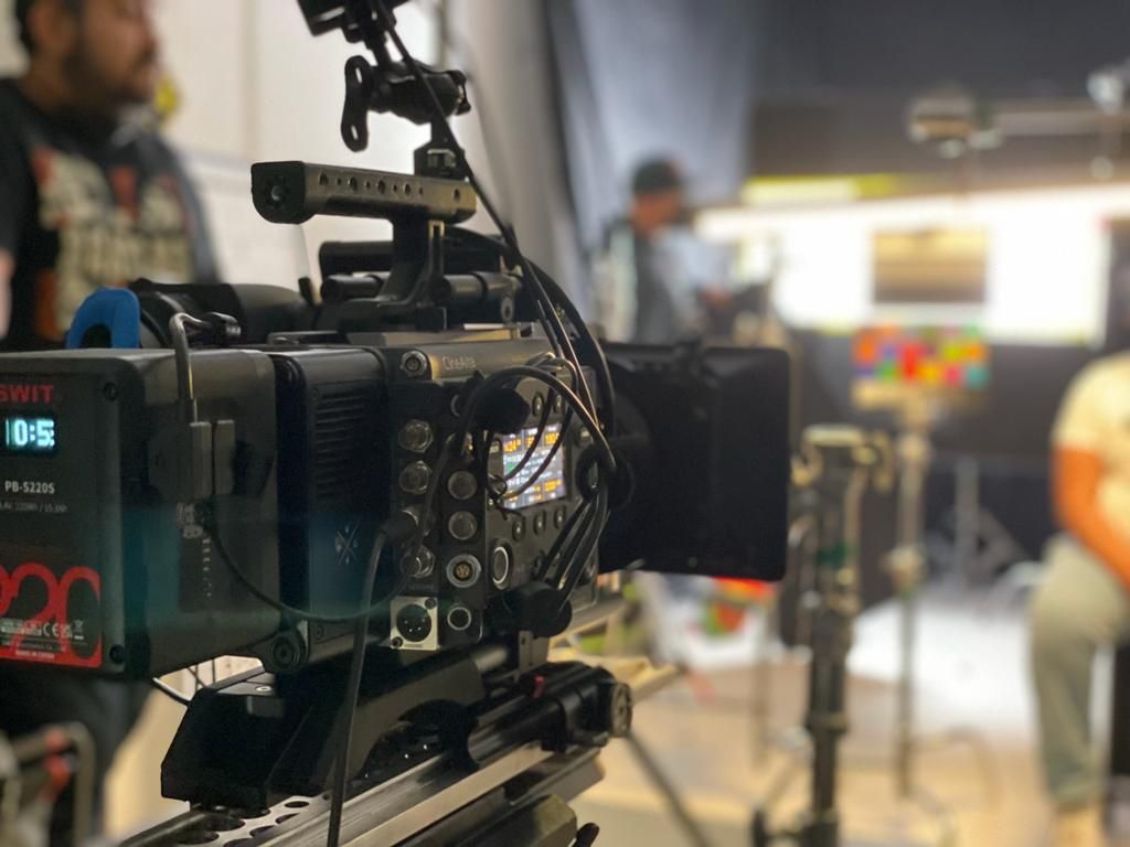 Una cámara está colocada sobre un trípode en una habitación.