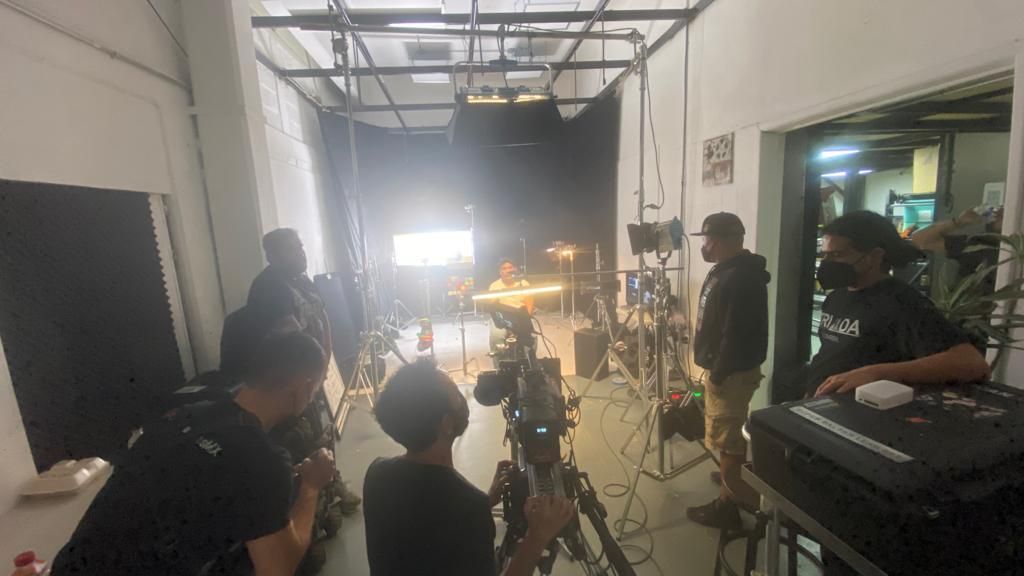 Un grupo de personas está de pie en una habitación con una cámara.