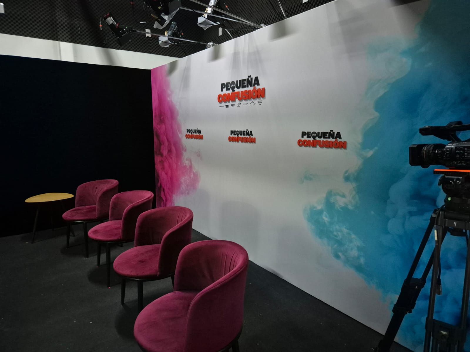 Una fila de sillas frente a una pared con la palabra pequeña escrita en ella.