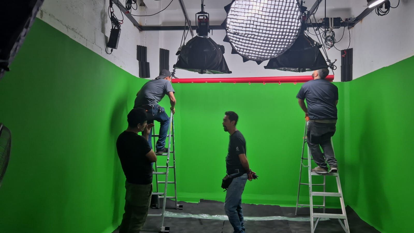 Un grupo de hombres está trabajando en una pantalla verde en un estudio.