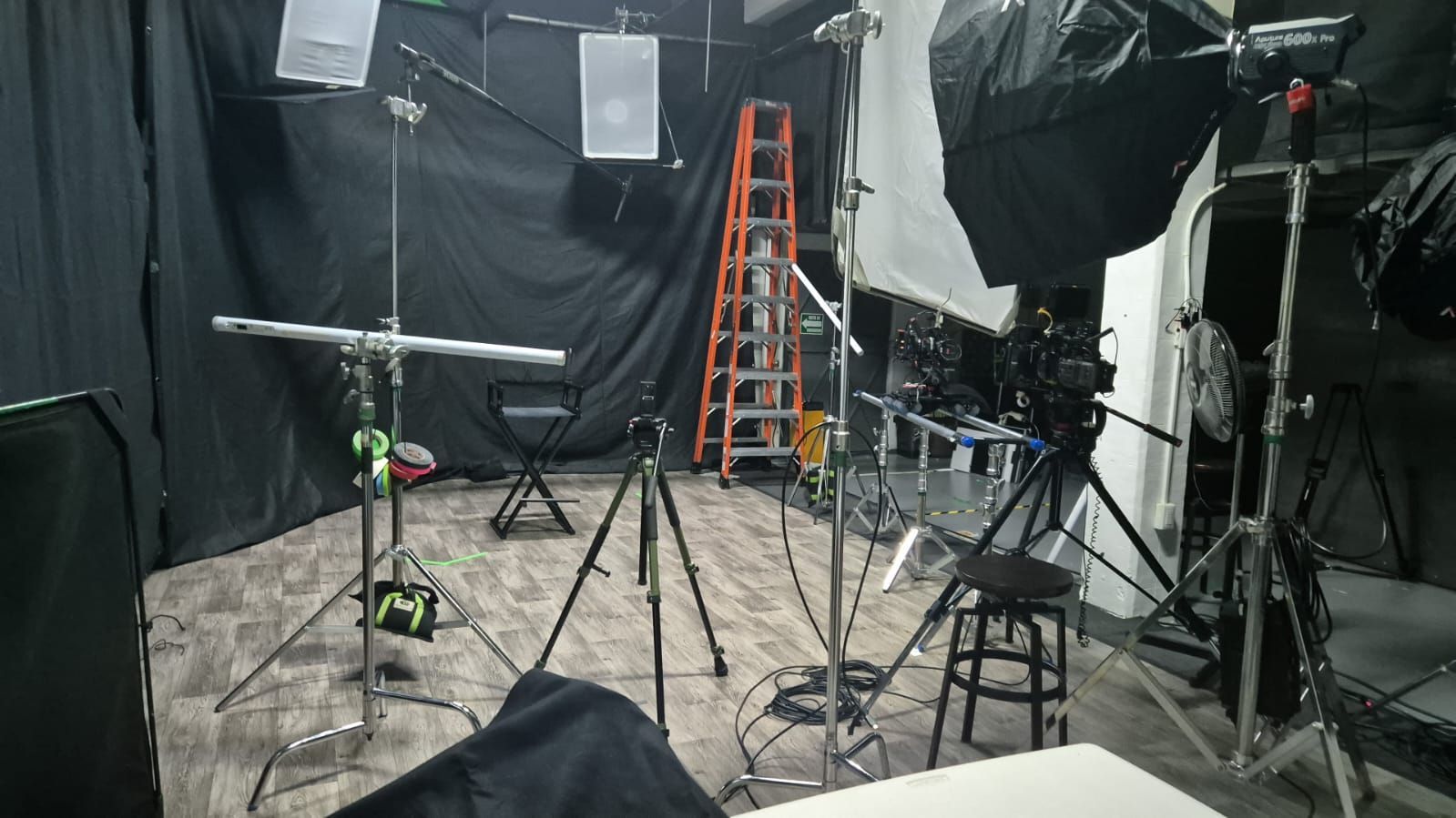 Un estudio fotográfico con mucho equipo y una escalera.