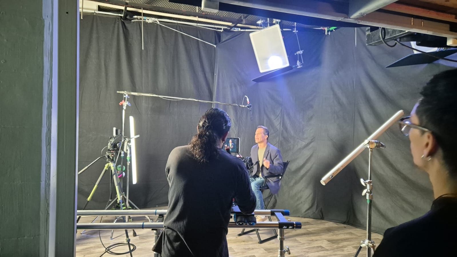 Un hombre está parado frente a una cámara en un estudio.