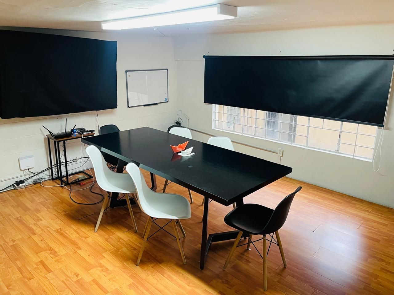 Una sala de conferencias con una mesa larga y sillas.