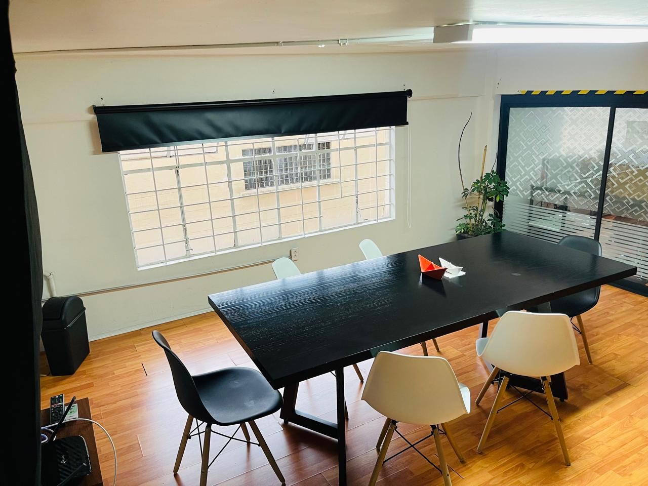 Una habitación con una mesa y sillas frente a una ventana.