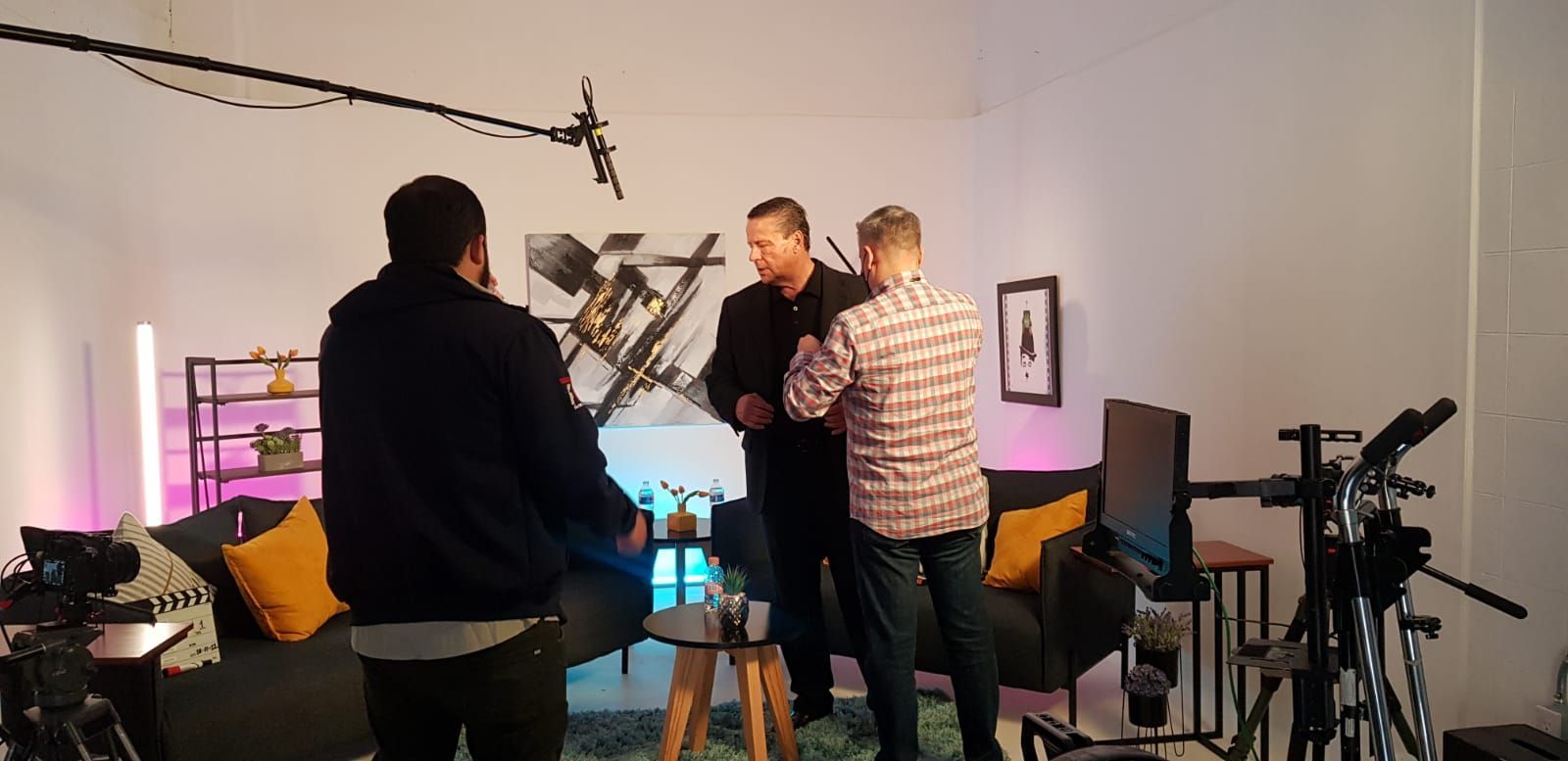 Un grupo de hombres están de pie en una sala de estar hablando entre ellos.