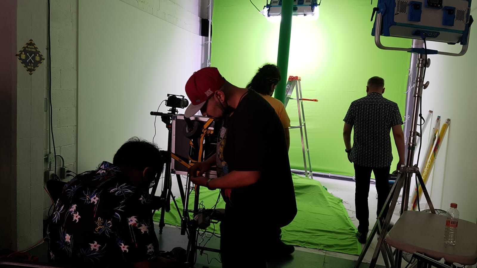 Un grupo de hombres está trabajando en una pantalla verde en un estudio.