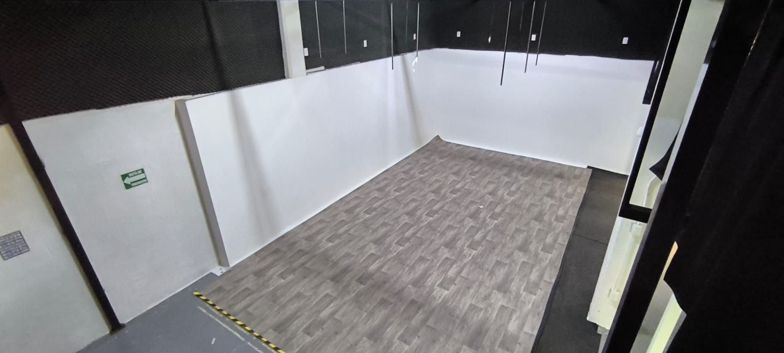 Una habitación vacía con suelo de madera y paredes blancas.