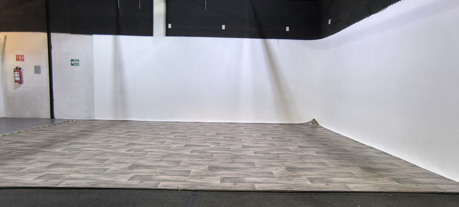 Una gran habitación vacía con piso de ladrillo y paredes blancas.