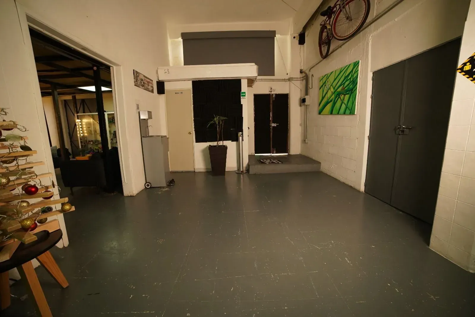 Una gran habitación vacía con una bicicleta en la pared.