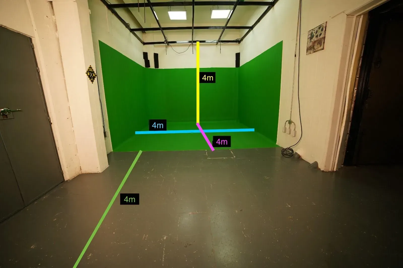 Una habitación con una pared verde y un suelo gris.