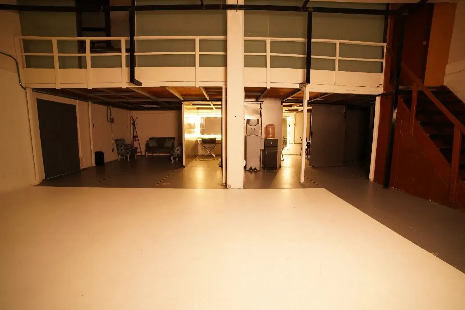 Una gran habitación vacía con balcón y escaleras.