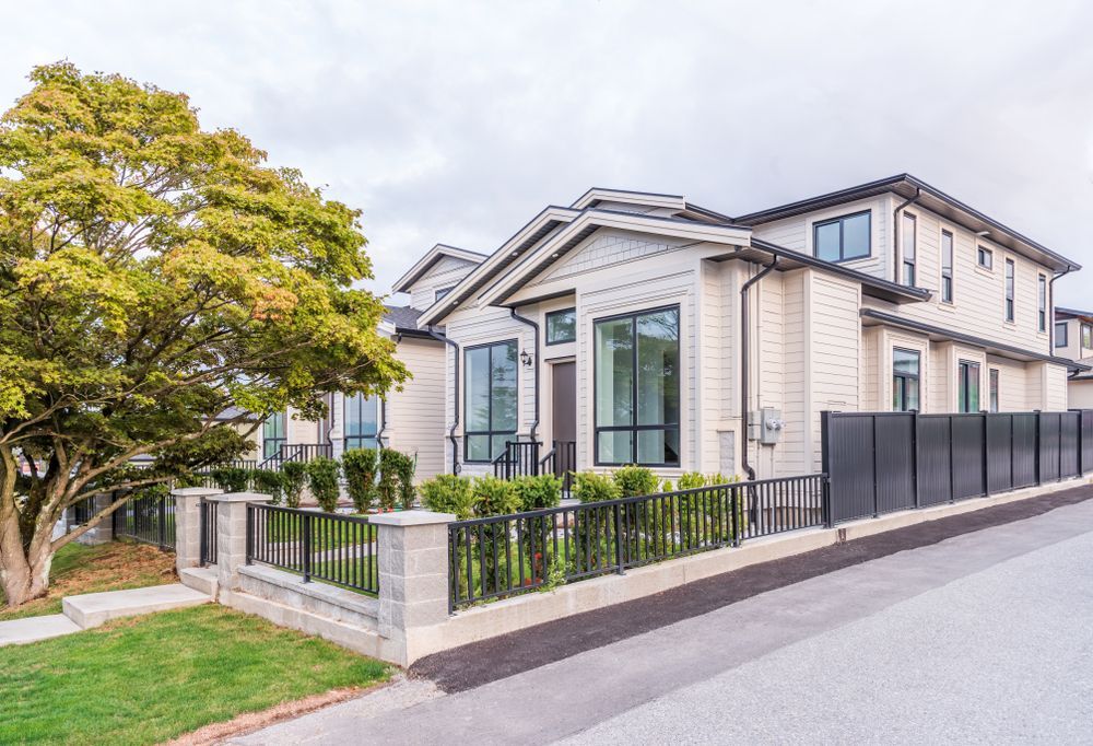 Beige Multi-story House With Black-framed Windows, a Black Fence — Property Transfer Professionals In Warnervale, NSW