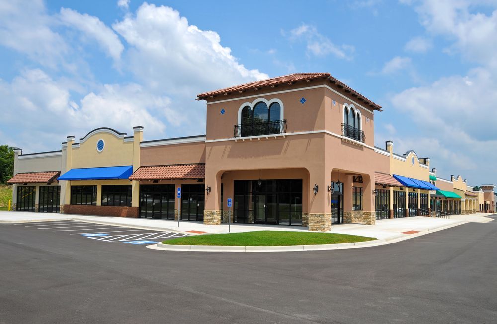 Empty Retail Storefronts in a Strip Mall, Tan and Light Blue Exterior — Property Transfer Professionals In Wyong, NSW