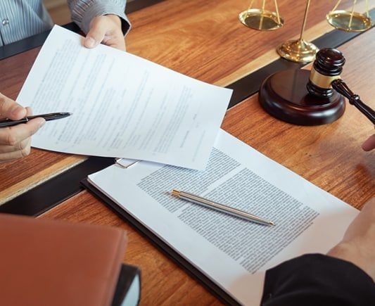 Two People Reviewing Legal Documents, Scales of Justice and Gavel — Property Transfer Professionals In Wyong, NSW