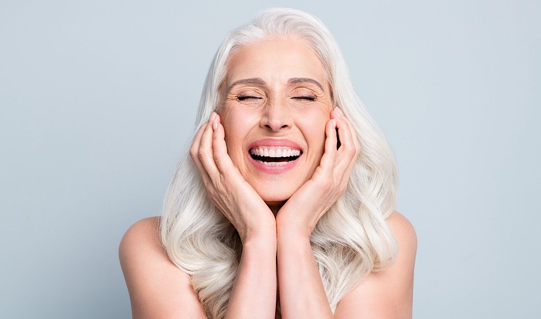 elderly, retired  woman showing off her new smile after getting affordable dental implants