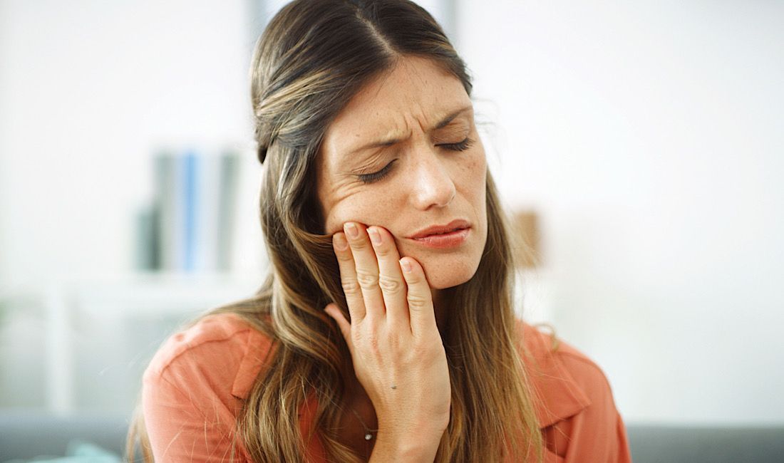 Woman experiencing tooth sensitivity when eating or drinking anything cold in Salinas, CA.