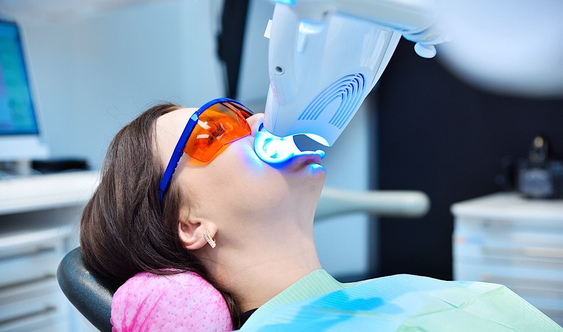 Female patient at the dentist getting a professional whitening treatment done in Salinas, CA.