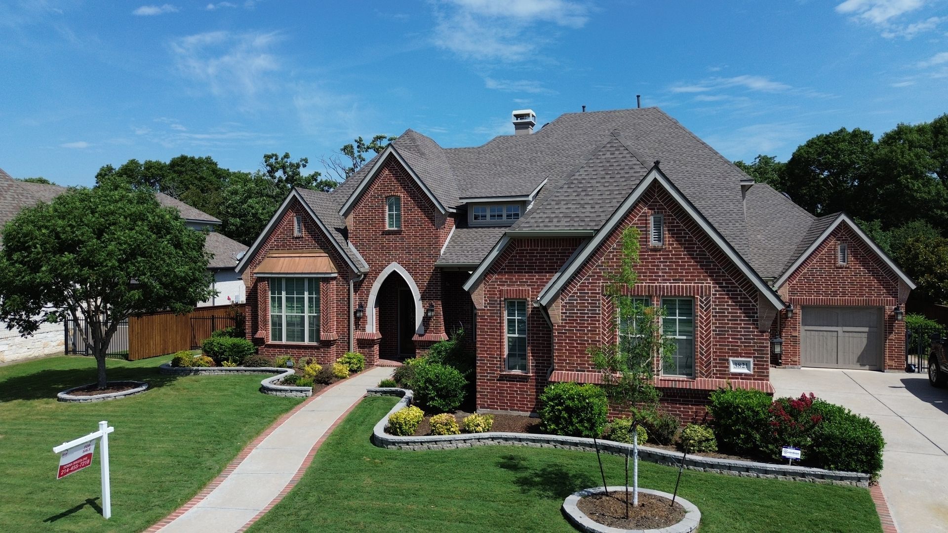 Brick house with arched entrance, green lawn, and a 