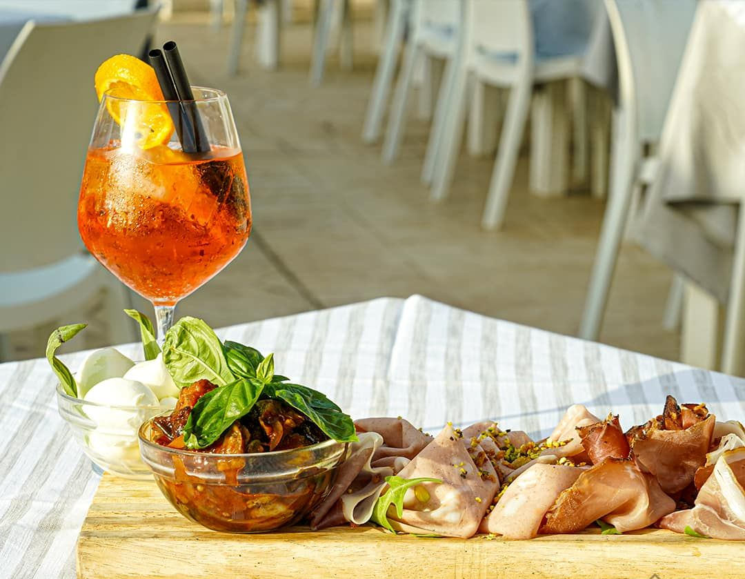 Aperol spritz con salumi e mozzarella su un tavolo.