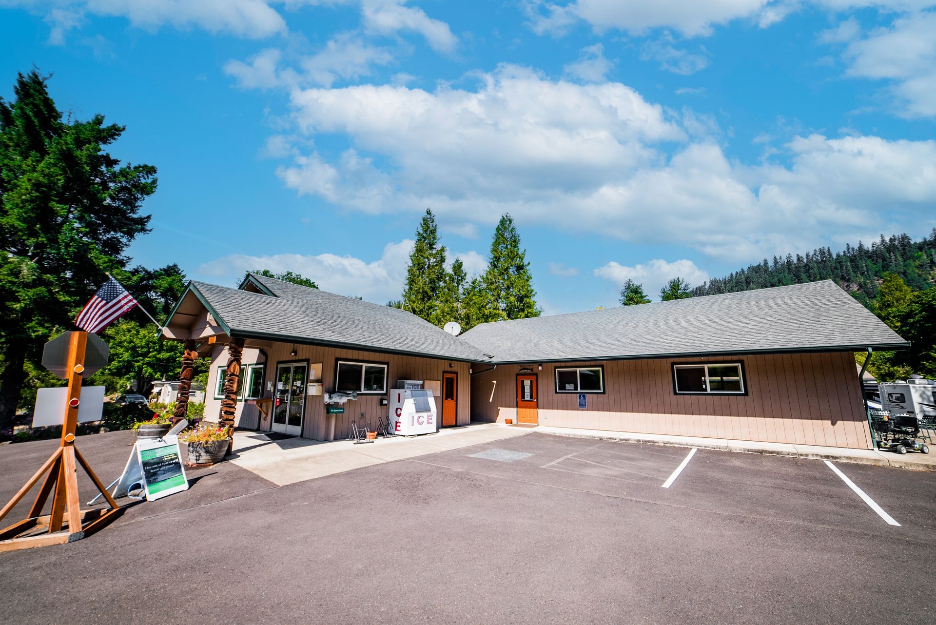 A single-story building with a parking lot. An American flag flies near the entrance.