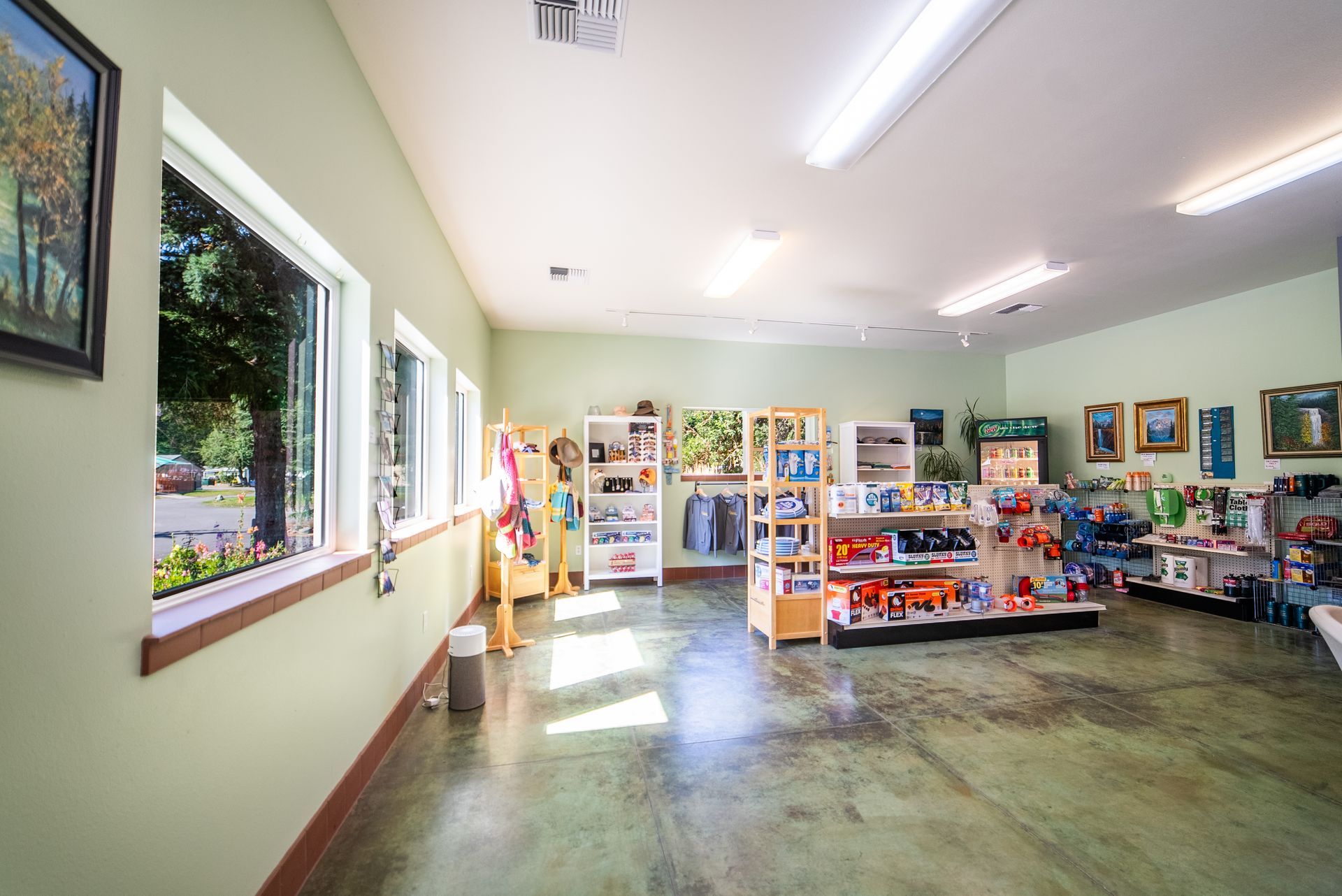 Interior of a retail store with shelves of merchandise and windows along the wall.