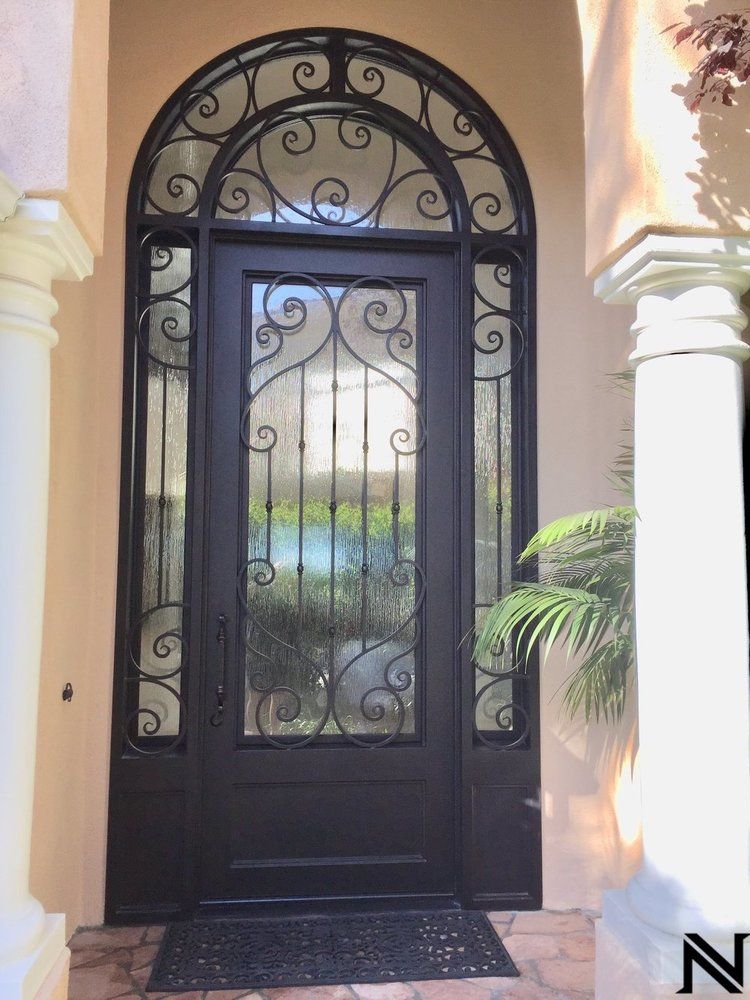 The front door of a house has a wrought iron design on it