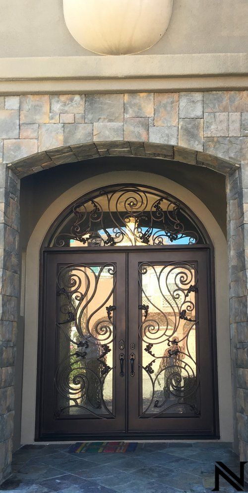 The front door of a house has a wrought iron design on it.