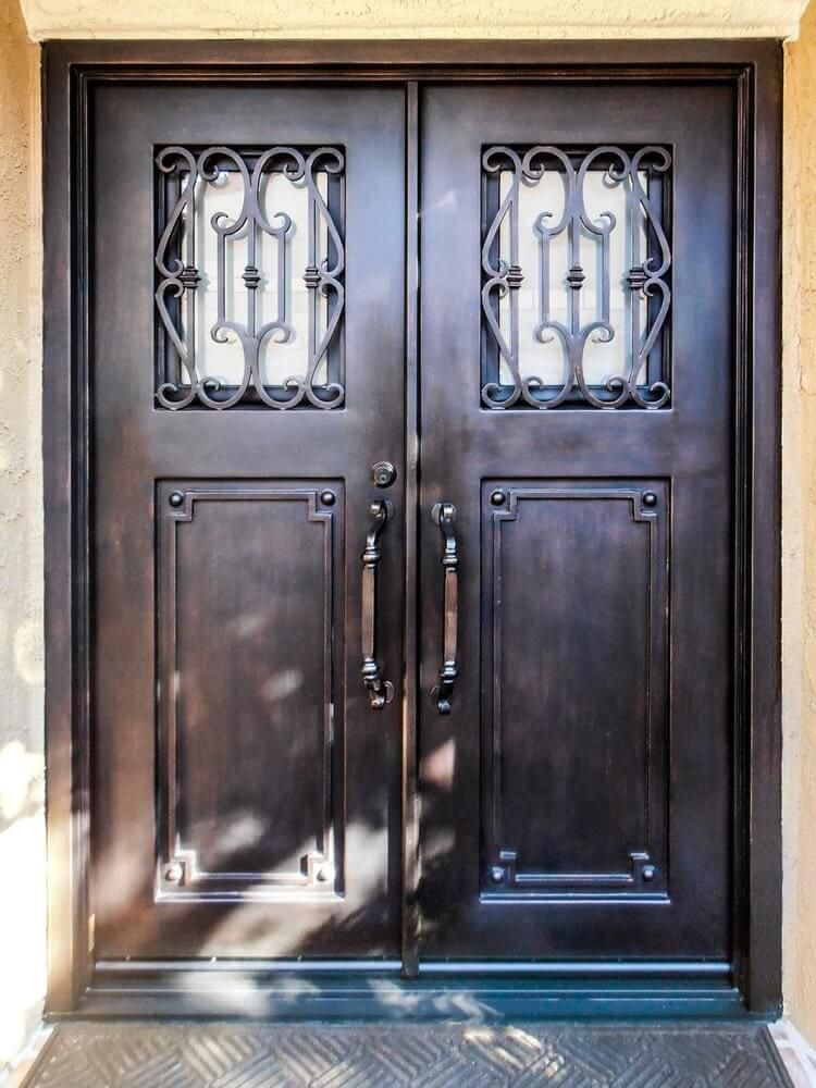 A black double door with a wrought iron design on it