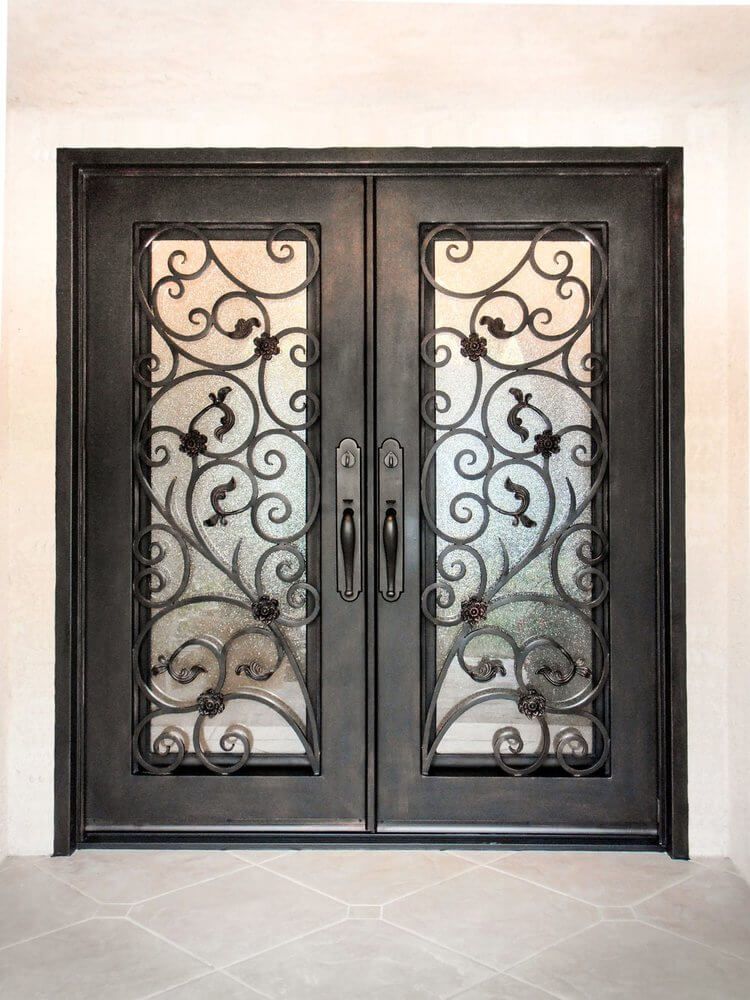 A pair of wrought iron double doors with a wrought iron design on them.