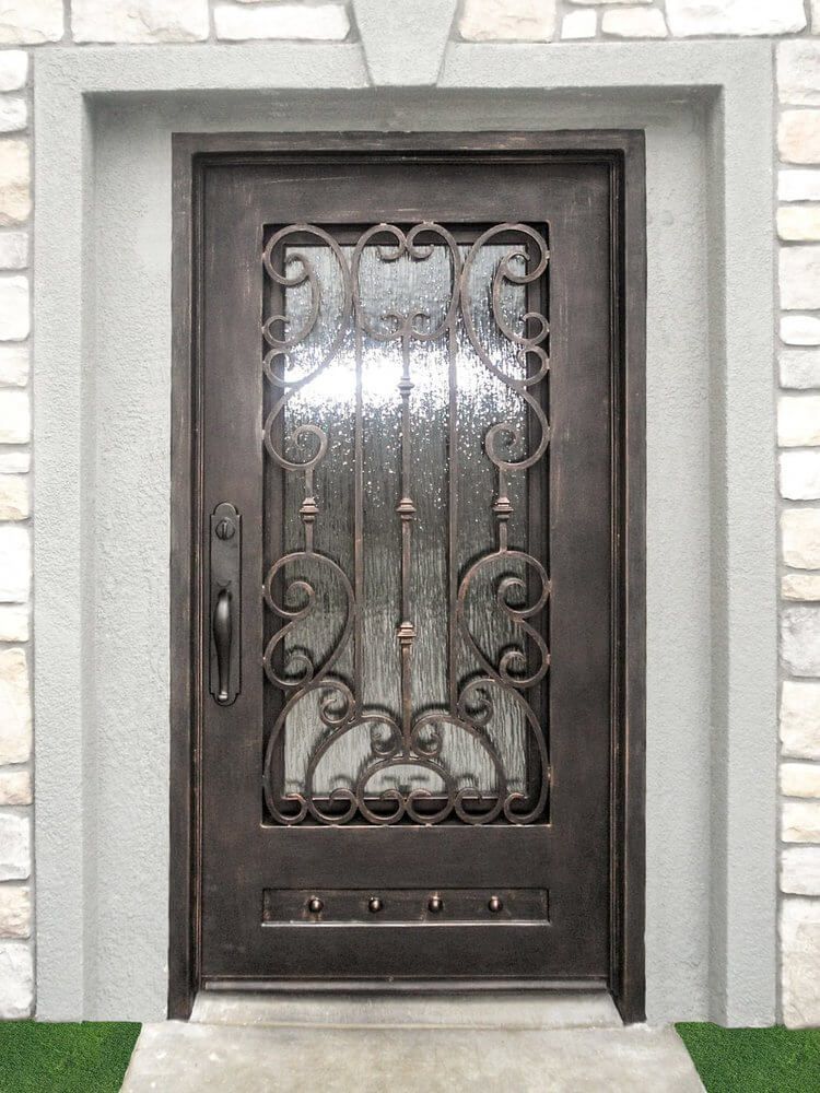 A wrought iron door with a glass window is in front of a stone wall.