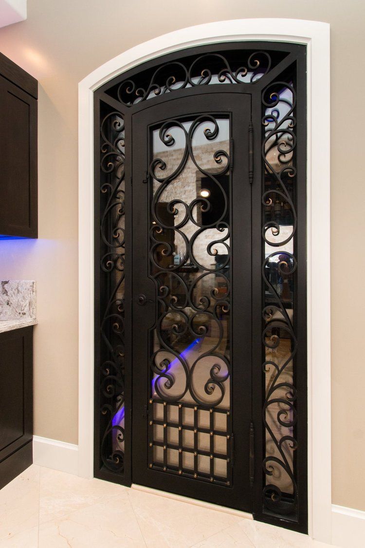 A wrought iron door with a glass window in a room.