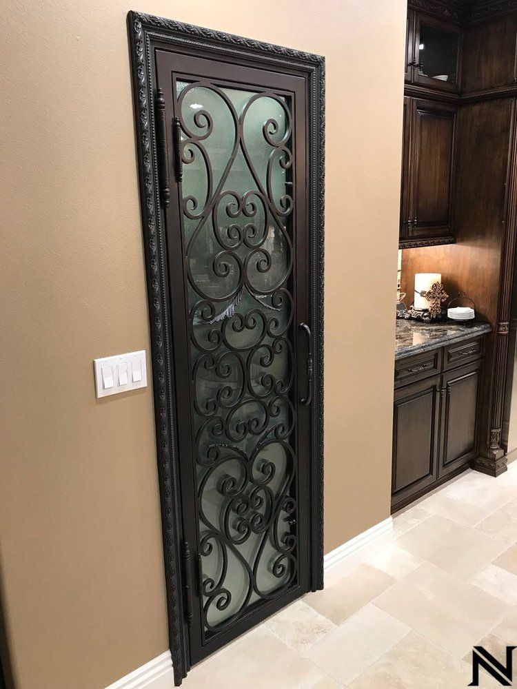 A wrought iron door with a frosted glass panel in a kitchen.