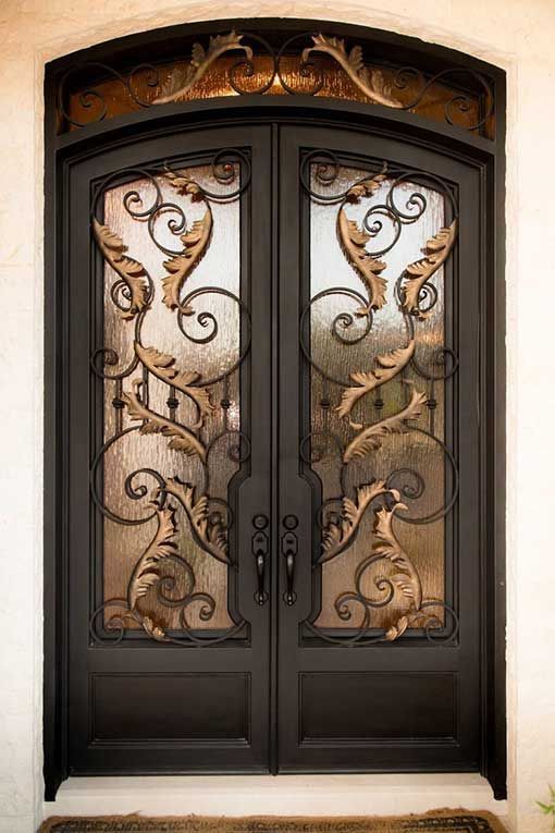 A pair of wrought iron doors with a fancy design on them.