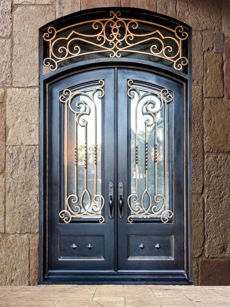 A black and gold wrought iron door is on a brick wall.