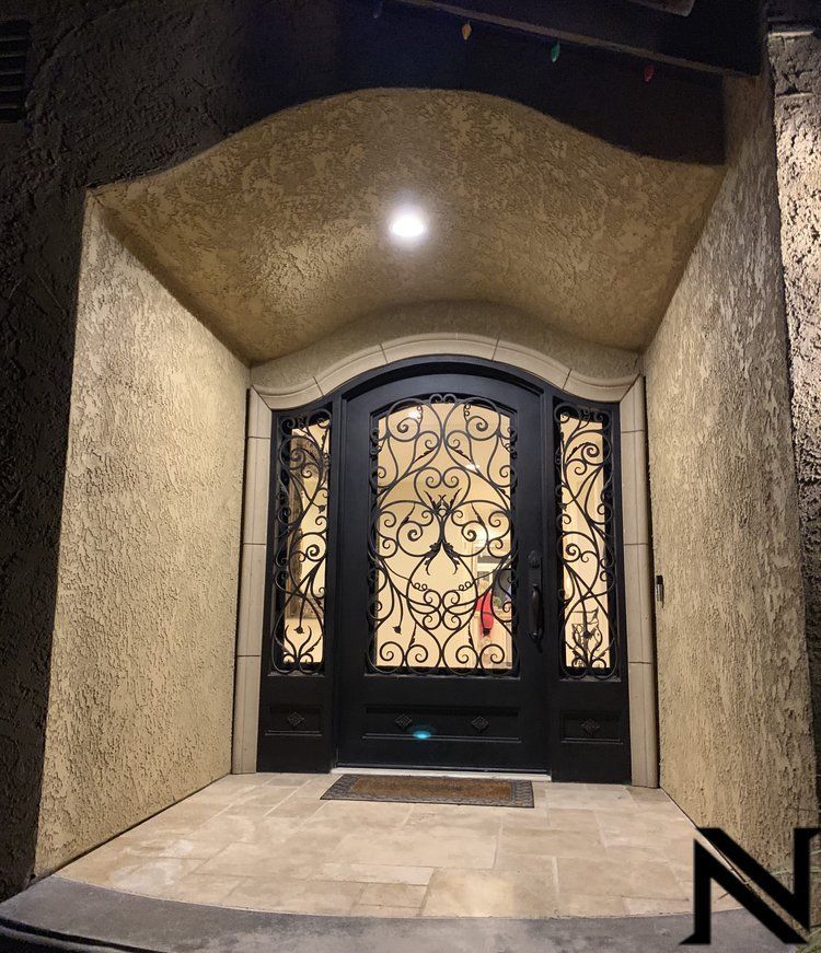 A black door with a wrought iron design on it