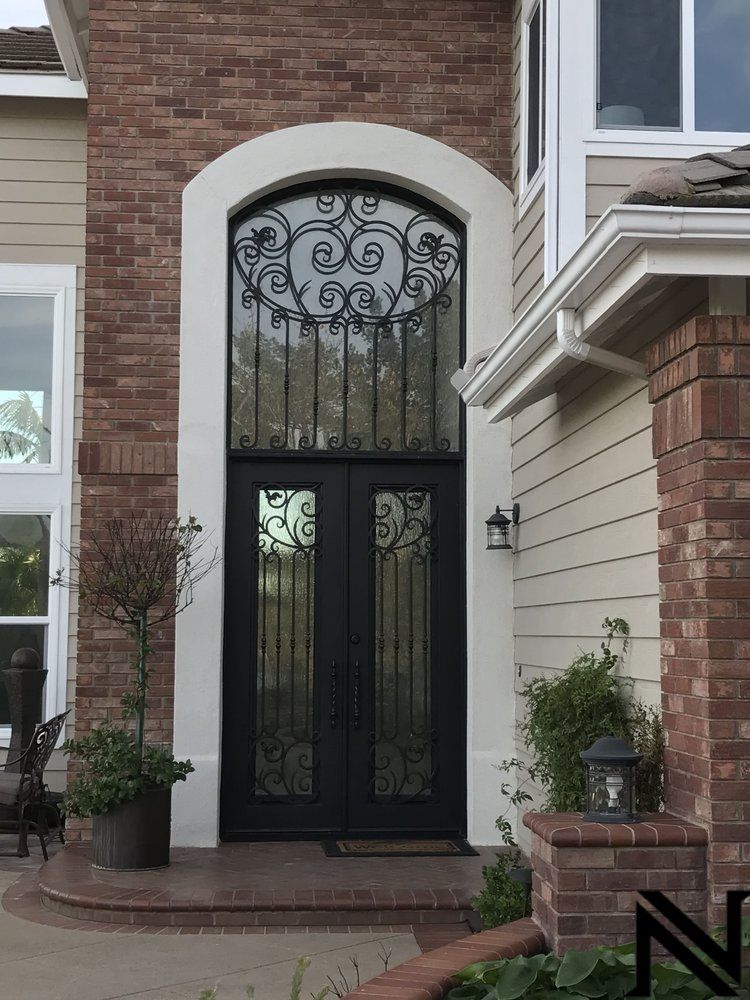 The front door of a house has a wrought iron design on it