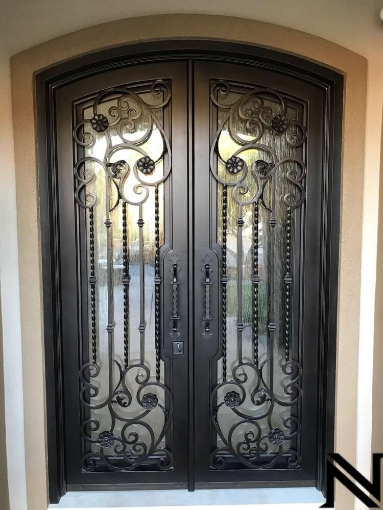 A pair of wrought iron doors with a fancy design on them.