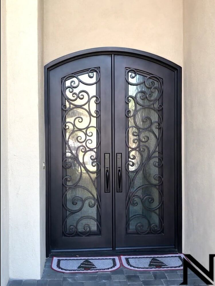 A black wrought iron door with a swirl design on it.
