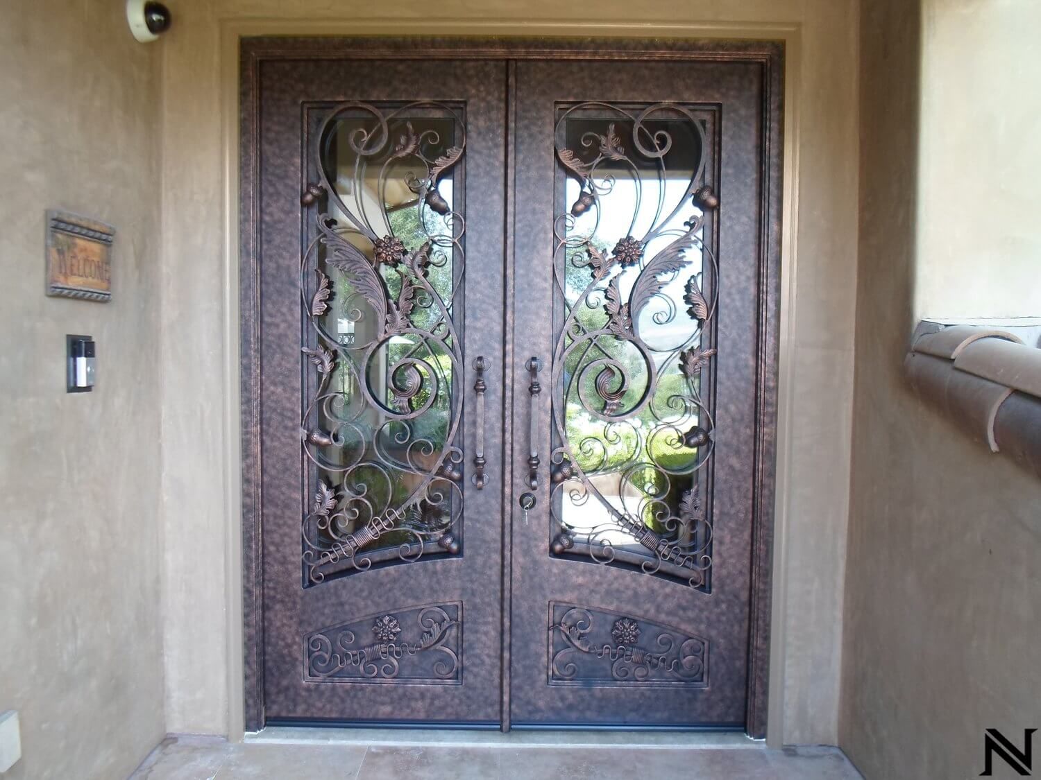 A pair of wrought iron doors are sitting on top of a tiled floor.