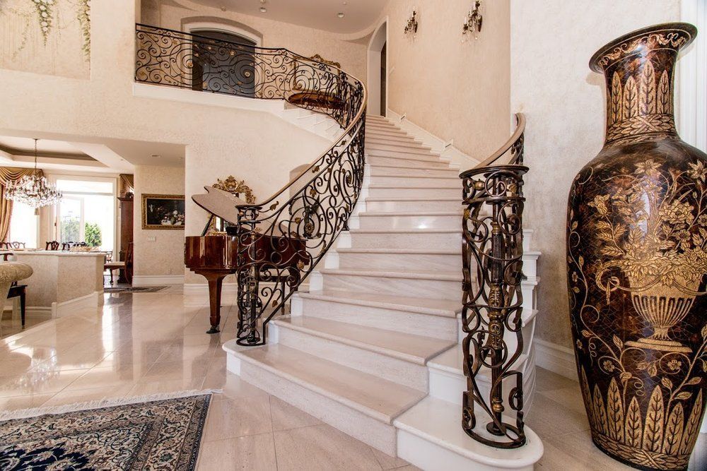 A staircase in a house with a vase and a piano