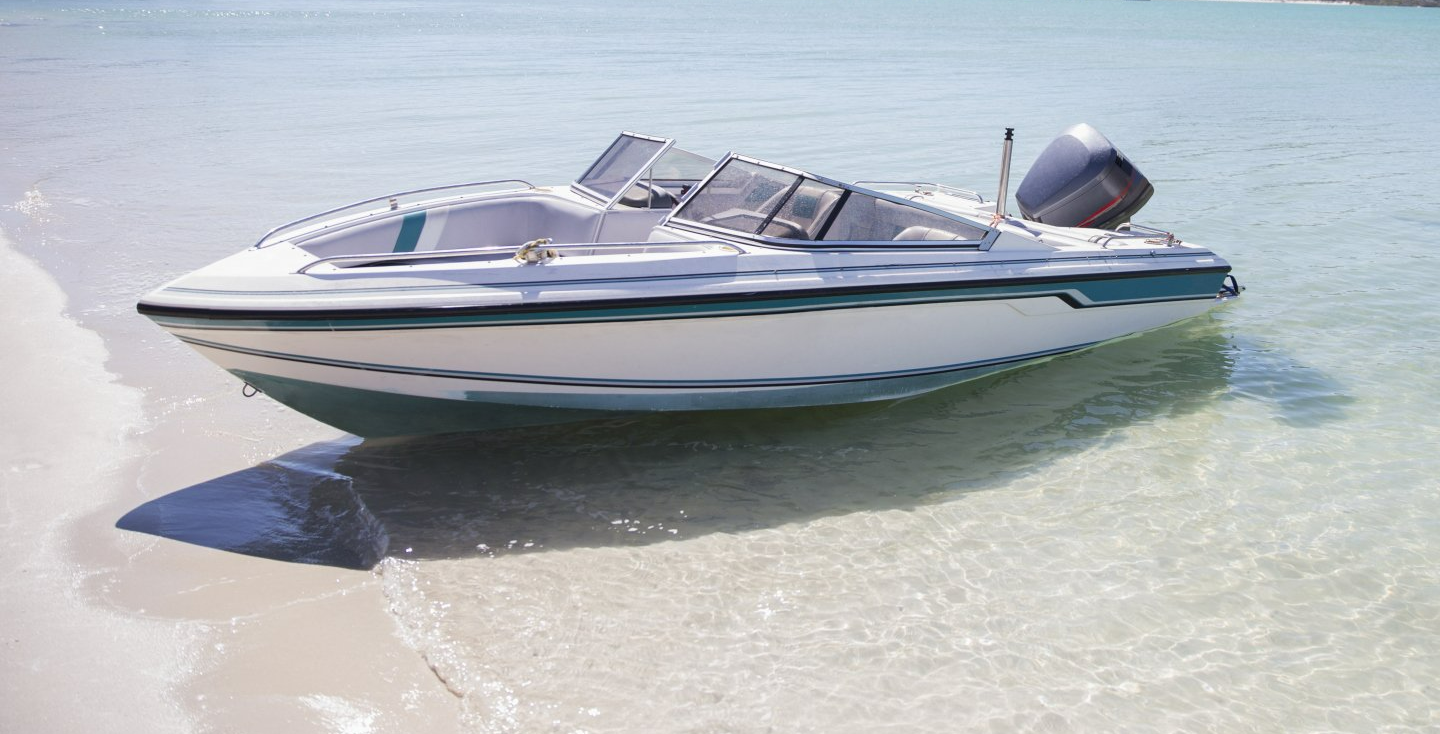 A boat is sitting in the water on the beach