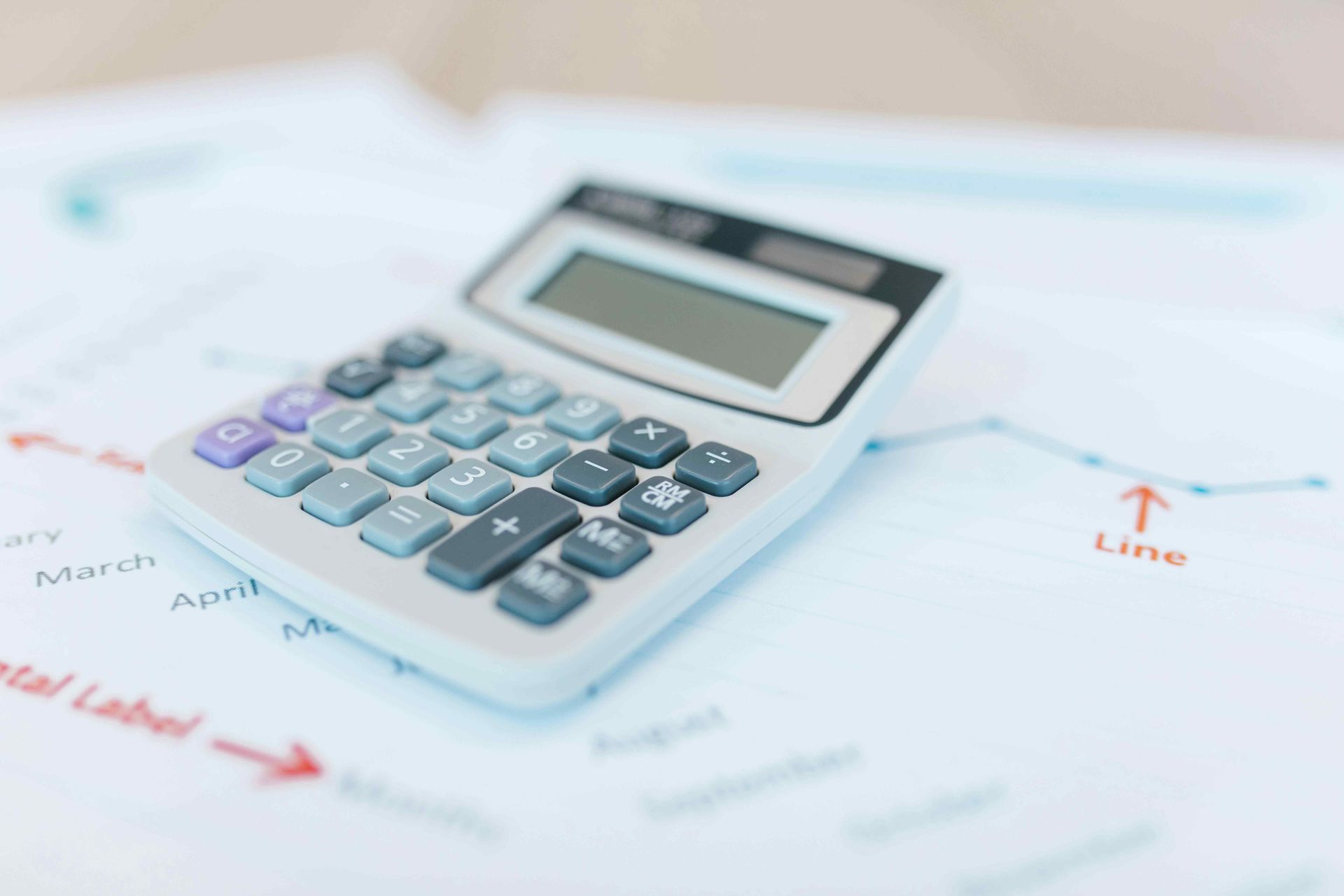 Calculator on a chart with a rising line, possibly financial data or statistics.